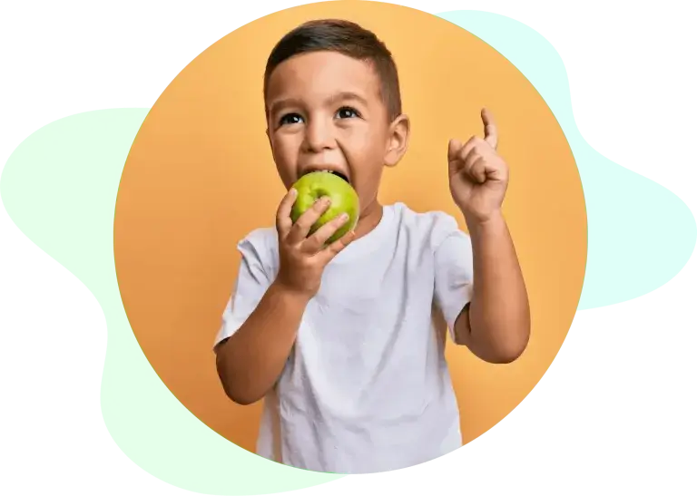 preschool boy eating apple while learning